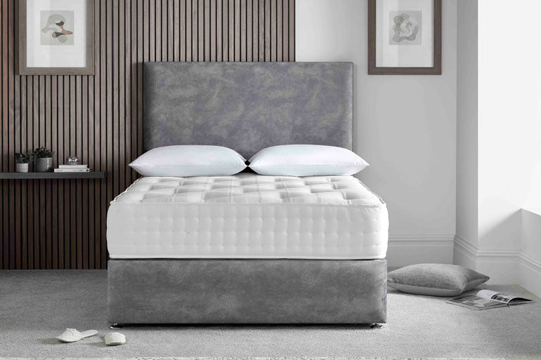 Gray upholstered bed with white mattress in a bedroom setting