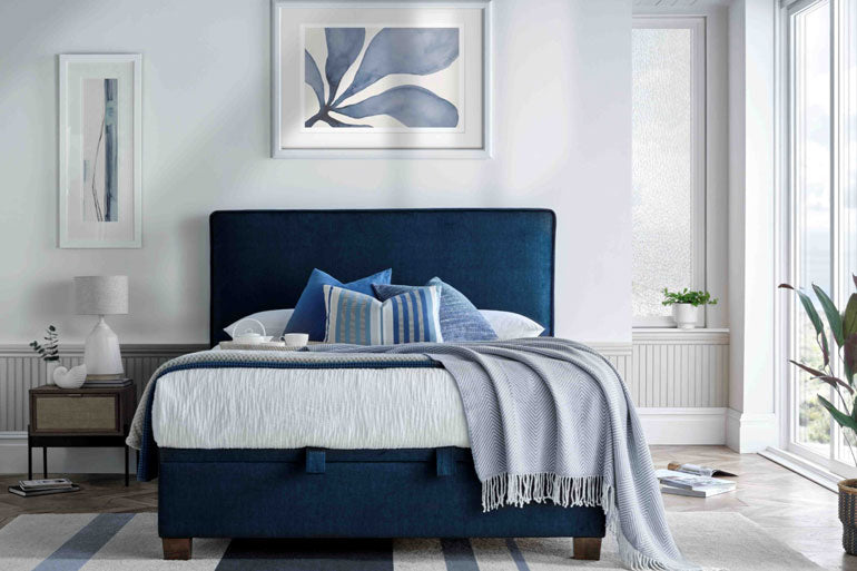 A Kaydian Newton Ottoman Bed in Vogue Ocean Blue, placed in a stylish bedroom setting.