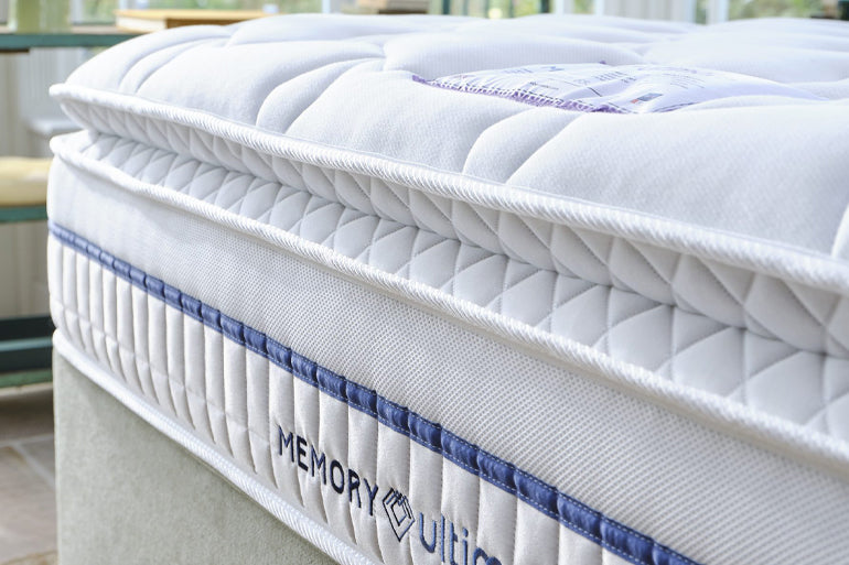 Memory foam mattress with quilted surface and brand logo on a blurred background