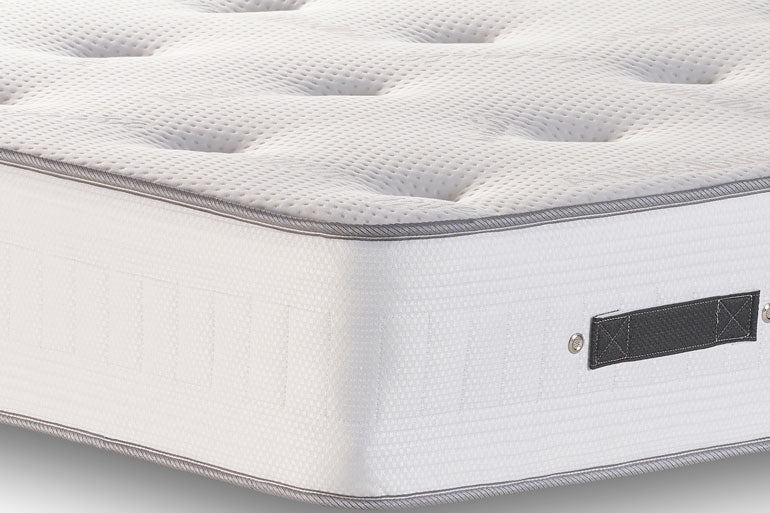 Close-up of a orthopaedic mattress with a brand label on a white background