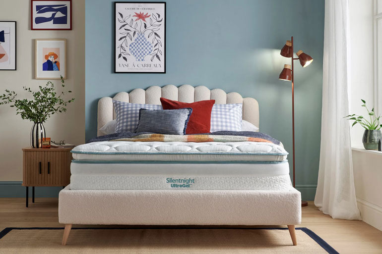 Bedroom with a neatly made bed featuring a Silentnight UltraGel 2000 Pillowtop mattress, colorful pillows, and a side table.
