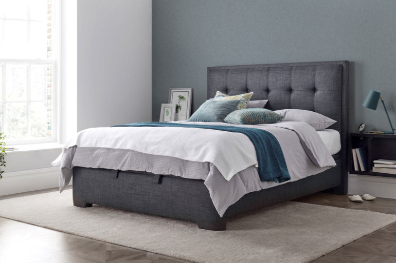 Kaydian Falstone Ottoman Bed in bedroom against a green wall with white bedding.