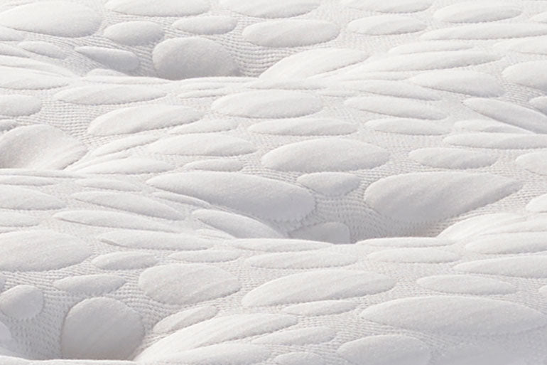 Close-up of a textured white mattress surface