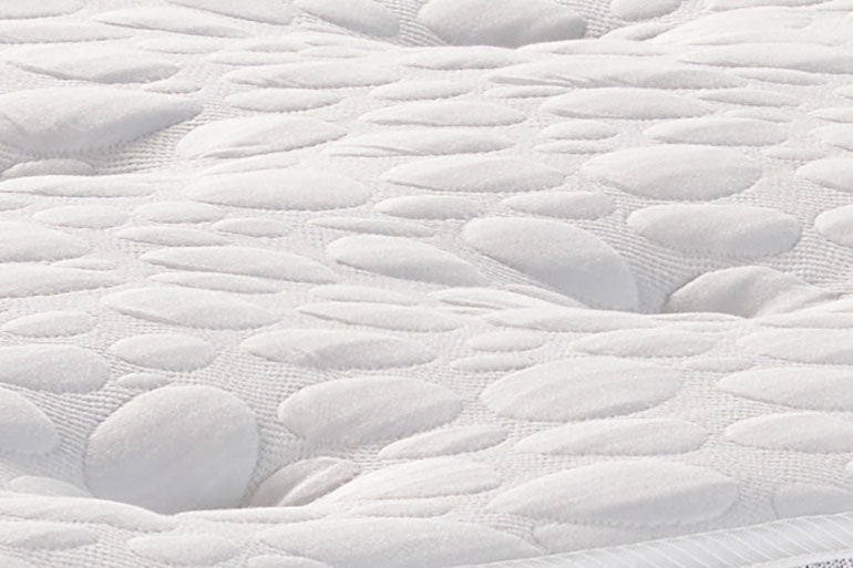 Close-up of a textured white mattress surface