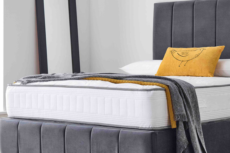 Classic Pocket 1000 Mattress with gray headboard and yellow pillow on a bed