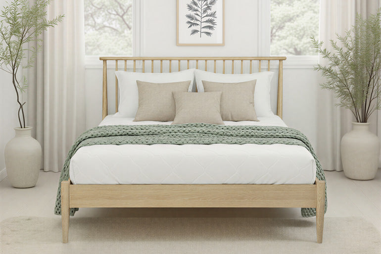 Front view of Flintshire Grosvenor Oak Bed with bedding on in bedroom setting