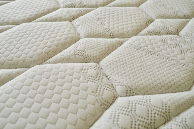 Close-up of a textured beige mattress cover