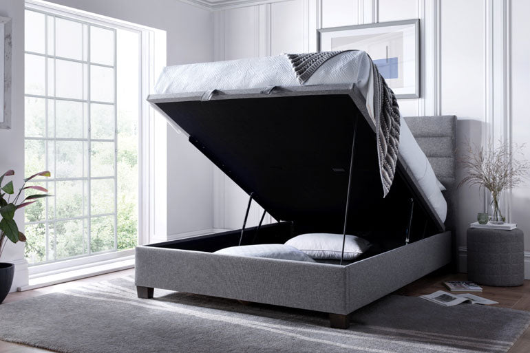 Kaydian Appleford Ottoman bed in Marbella Grey with open storage compartment in a bright bedroom.