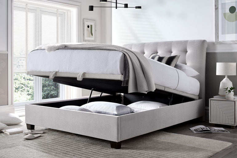 Kaydian Ashbrooke Ottoman bed in Maskat Clay with storage slightly open in a bedroom setting.