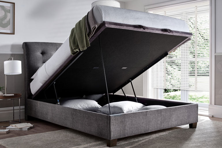 Kaydian Ashbrooke Ottoman Bed in Vogue Grey with storage compartment open in a bedroom setting