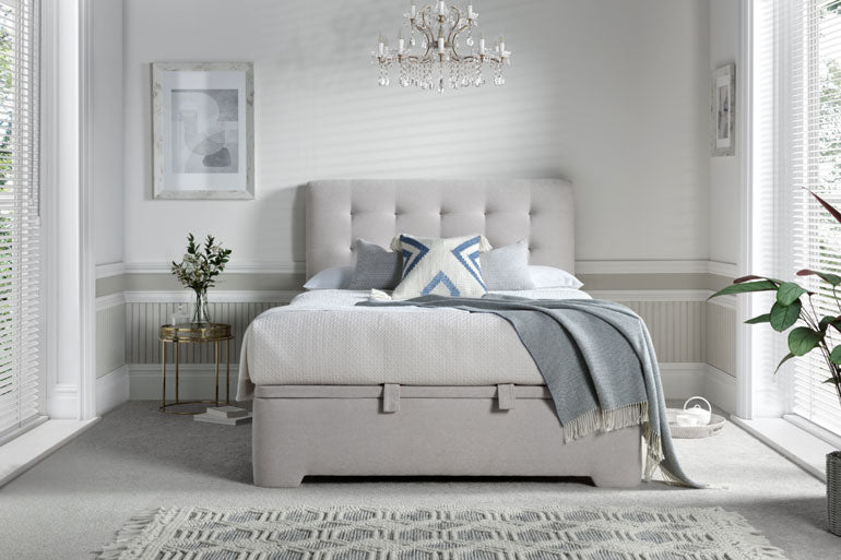 Neatly made Kaydian Ashgrove Ottoman Bed in a bedroom with a chandelier and decorative elements.