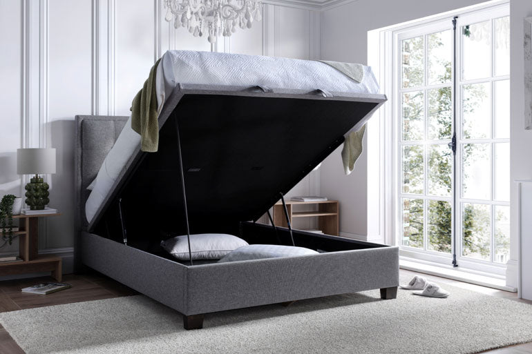 Kaydian Falfield Ottoman bed in Marbella Grey with open storage compartment in a bright bedroom.