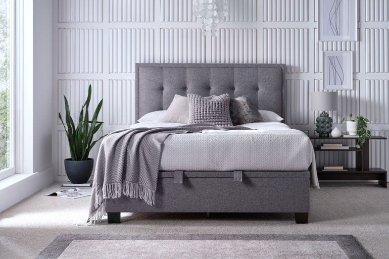 Kaydian Falfield Ottoman Bed in Marbella Grey upholstered bed in a modern bedroom with decorative elements.