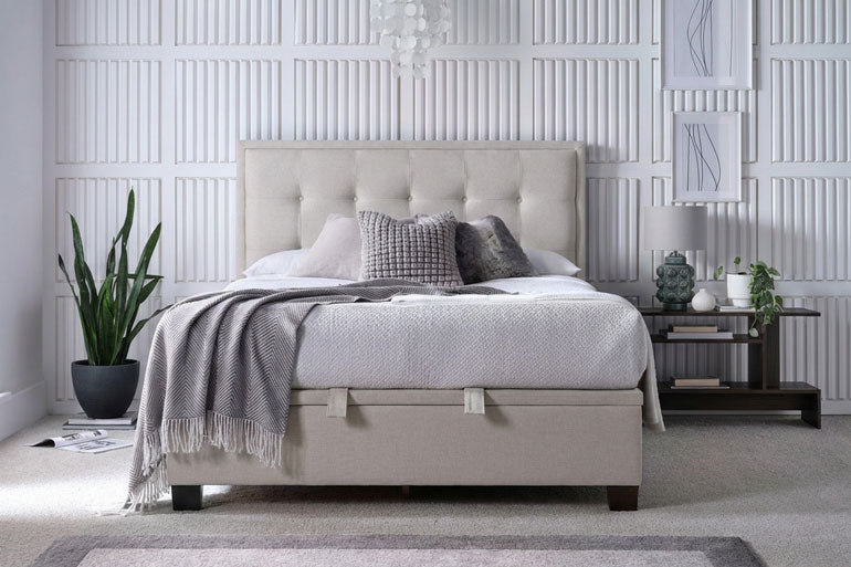 Kaydian Falfield Ottoman Bed in Maskat Clay in a modern bedroom setting with decorative pillows and plants.