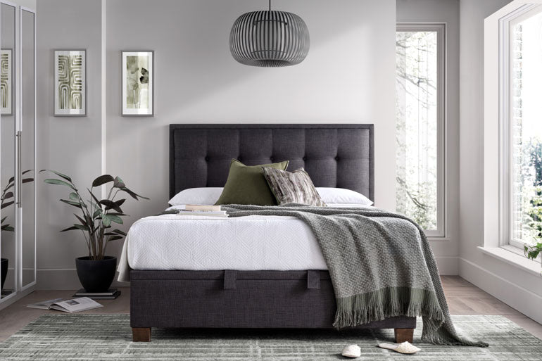 Kaydian Falfield Ottoman bed in Slate in a modern bedroom with white bedding and green throw.