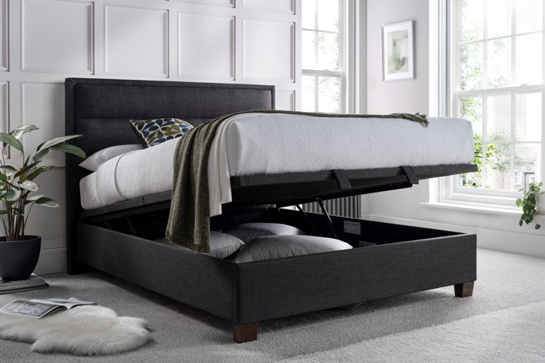Kaydian Kirkland Ottoman Bed in slate with storage drawers in a bright room with large windows.
