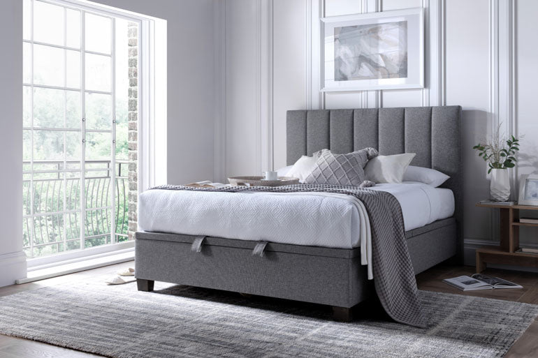 Kaydian Medlam Ottoman Bed in Marbella Grey bed in a bright bedroom with large windows.