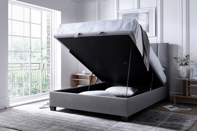 Kaydian Medlam Ottoman bed in Marbella Grey with open storage compartment in a bright bedroom.