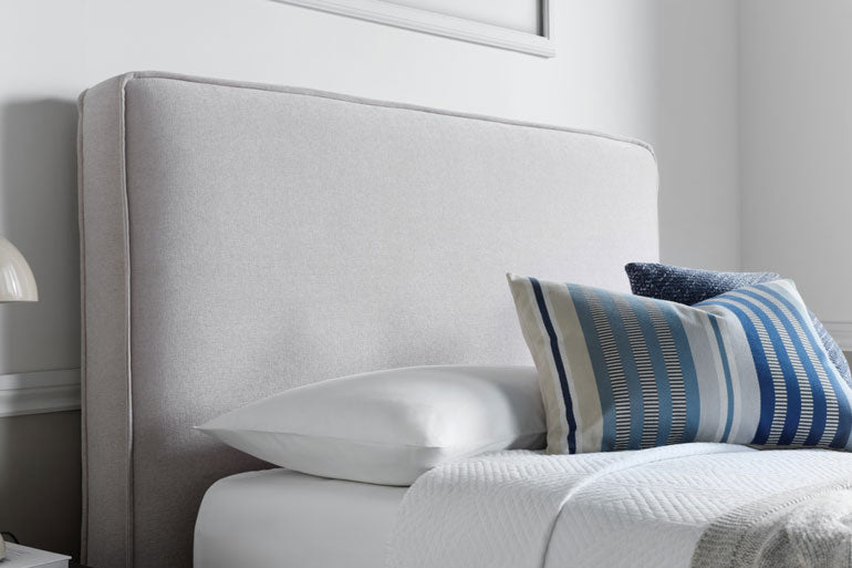 Kaydian Newland Ottoman headboard with pillows on a bed in a bedroom setting