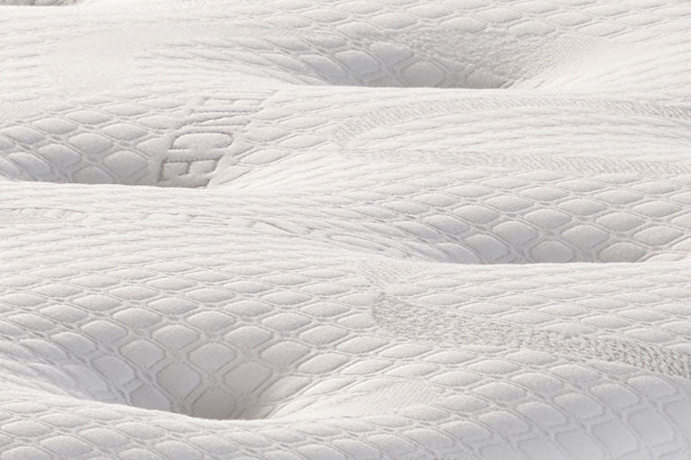 Close-up of a textured white mattress surface
