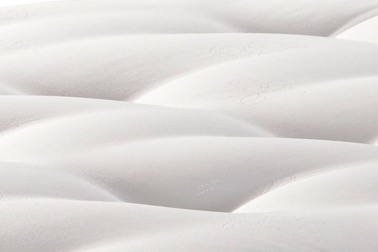 Close-up of a white quilted mattress surface
