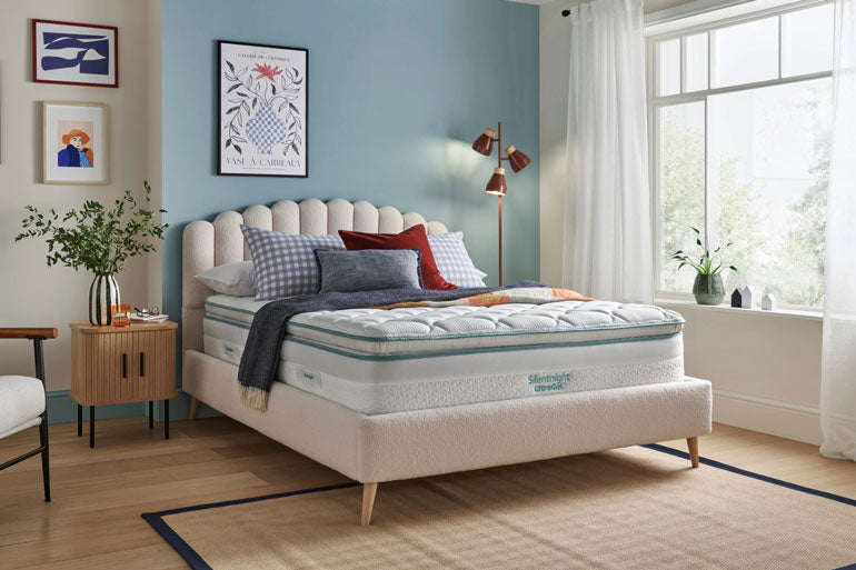 Bedroom with a Silentnight UltraGel 2000 Pillowtop Mattress on a bed, surrounded by decor elements.