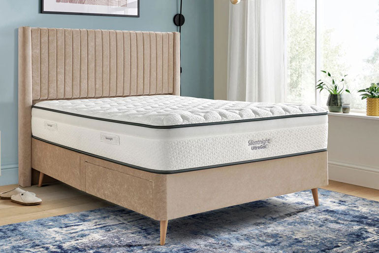 Beige bed with Silentnight UltraGel 2000 Pocket mattress in a room with a window and plants.