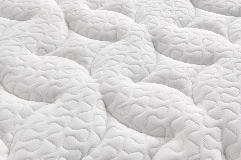 Close-up of a textured white mattress surface