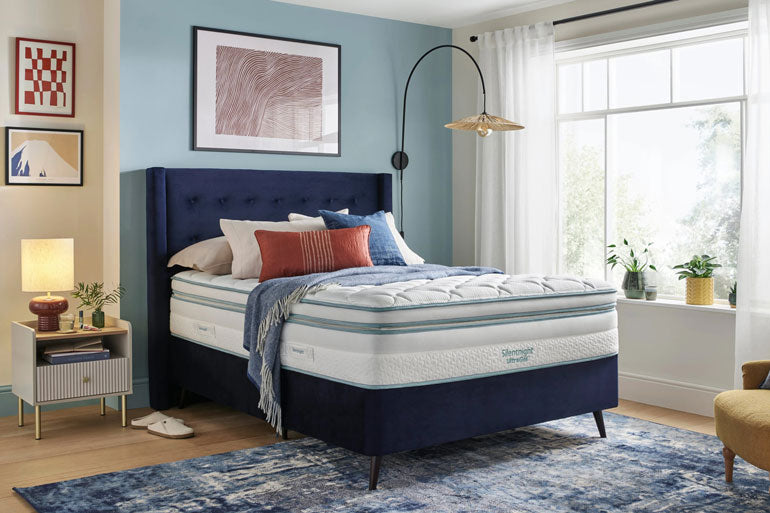 Bedroom with a blue upholstered bed and Silentnight UltraGel 3000 Boxtop mattress, featuring a nightstand and lamp.