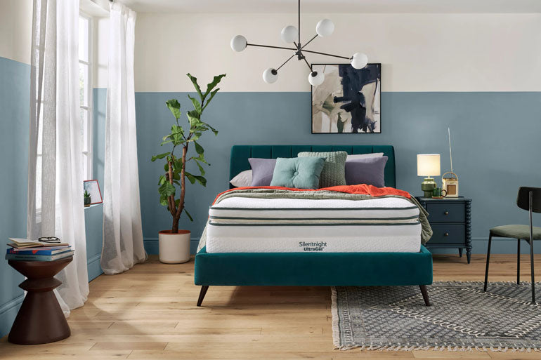 Bedroom with a teal bed frame and a Silentnight UltraGel 3000 Boxtop mattress, surrounded by decor elements.