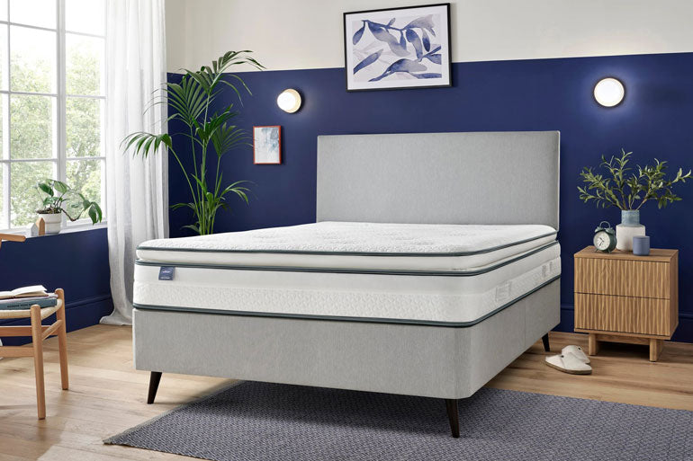 Silentnight UltraGel Miracoil Pillowtop mattress on a grey bed in a bedroom with blue walls, plants, and furniture.