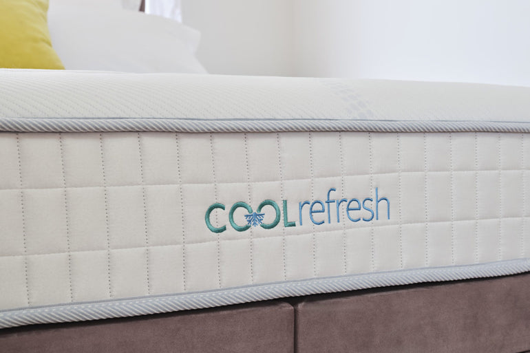 Mattress with 'Cool Refresh' branding on a bed
