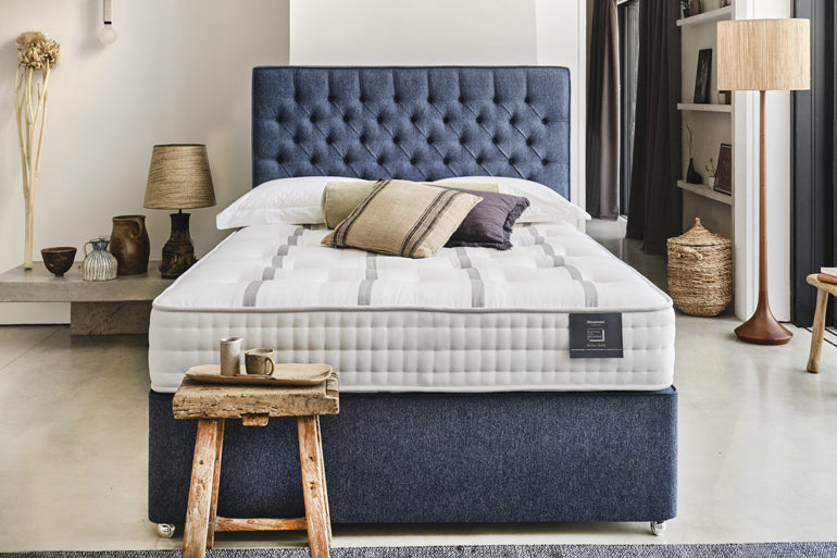 Blue upholstered headboard and base with ortho bespoke 1600 mattress on it in bedroom setting