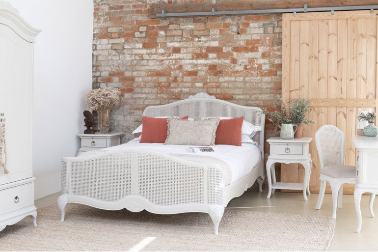 Willis &amp; Gambier Etienne Rattan Bed in bedroom setting against a brick wall with other matching furniture.