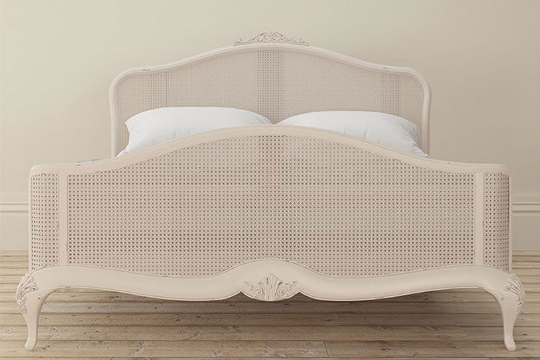 Willis &amp; Gambier Ivory Rattan Bed on a wooden floor.
