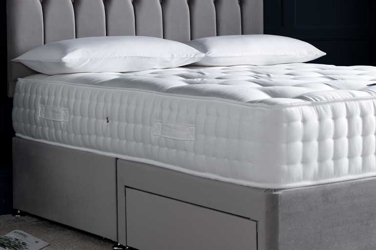 Close-up of Giltedge pocket sprung 2000 mattress side on grey divan base