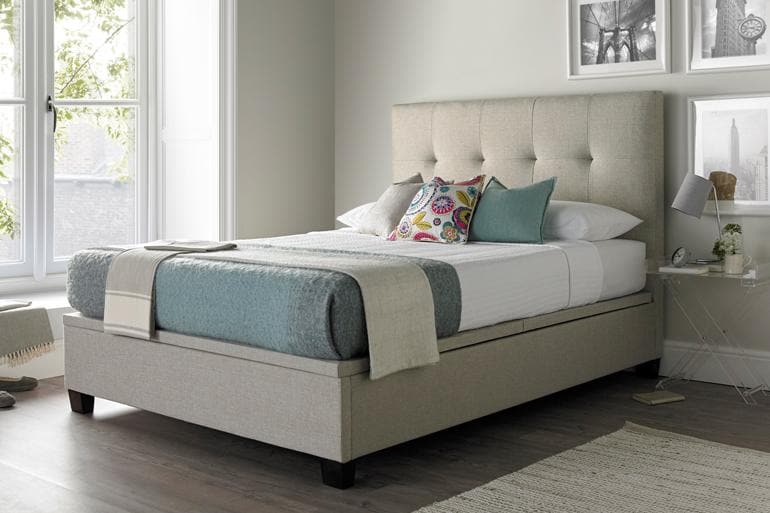 Kaydian Walkworth Ottoman Bed in Oatmeal in light bedroom with wooden floor.