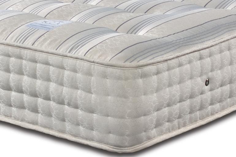 A white Sleepeezee Backcare Ultimate 2000 mattress with pocket springs and natural fibre fillings, featuring a patterned cover.